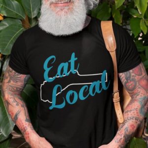 Older Hipster wearing glasses, shirt says Eat Local